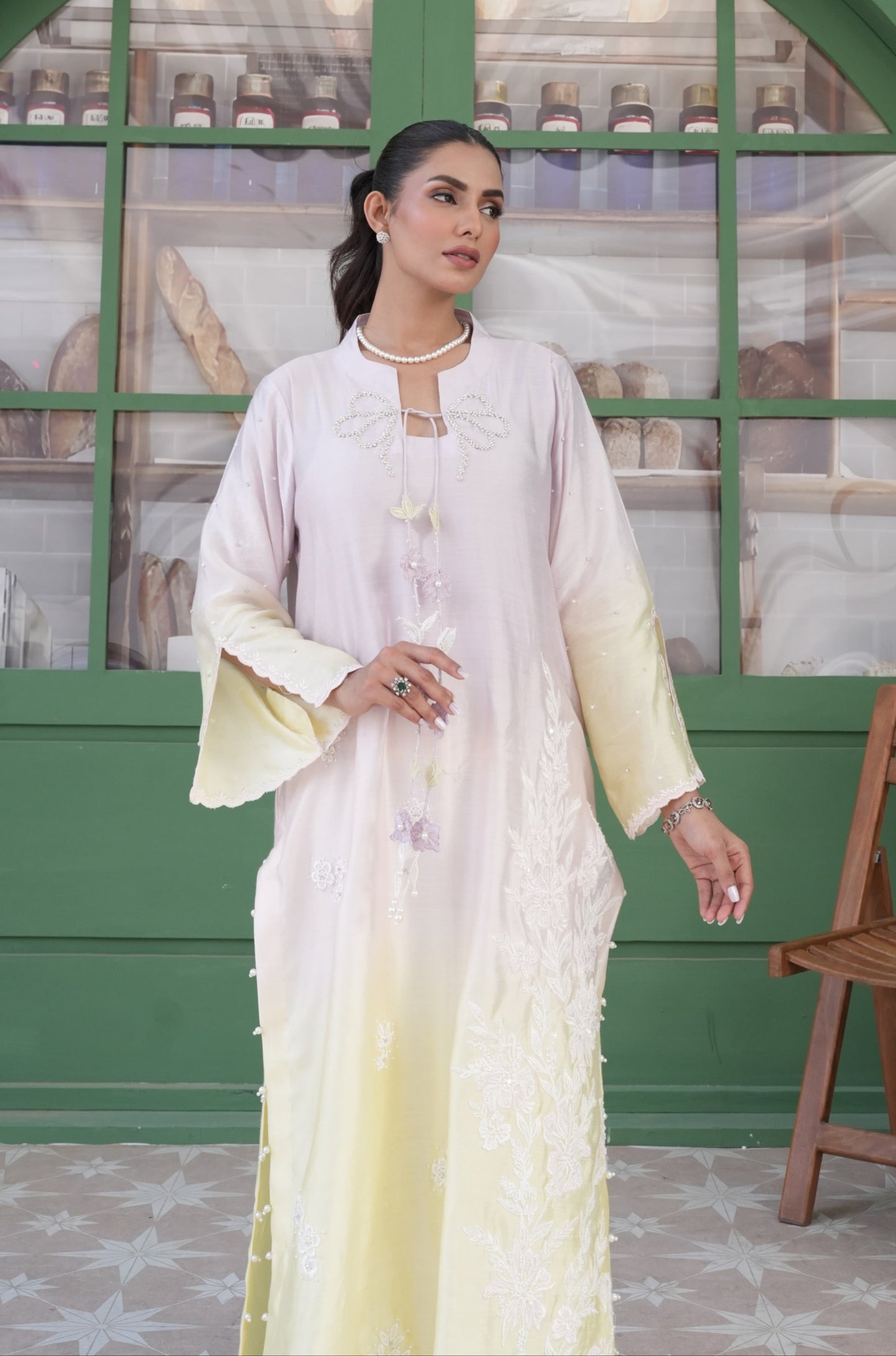 A Resplendent 3 Colour Ombre Long Shirt With Flare Pants Are Adorned With Intricate Handwork On The Neckline And Bunch Applique Inspired By Botanical Motifs, Cascading Effortlessly Down The Tussle Silk Ensemble. Accented With 3D Details, Flared Sleeves And A Flattering Neckline Seamlessly Add Elegance.
3 Piece Set.
Fabric: Tussle Silk