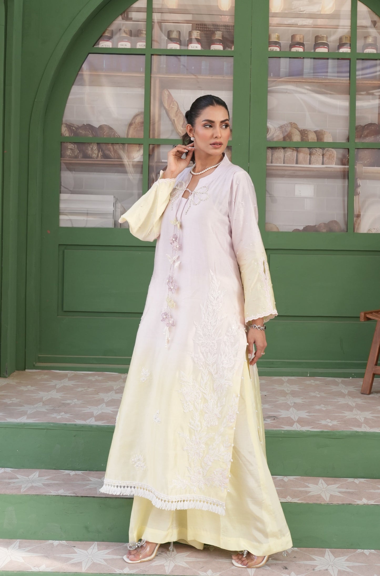 A Resplendent 3 Colour Ombre Long Shirt With Flare Pants Are Adorned With Intricate Handwork On The Neckline And Bunch Applique Inspired By Botanical Motifs, Cascading Effortlessly Down The Tussle Silk Ensemble. Accented With 3D Details, Flared Sleeves And A Flattering Neckline Seamlessly Add Elegance.
3 Piece Set.
Fabric: Tussle Silk
