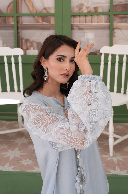 Radiating Timeless Elegance, A Powder Sheesha Silk Kaftan Is Detailed With Appliquéd Flowers And Pear Accents. The Neckline Is Adorned With Textured Detailing Tassels, Statement Sleeves Are The Cheery On Top. Comes With Straight Pants.
2-Piece Set.

Fabric: Sheesha Silk, Embroidered Fabric